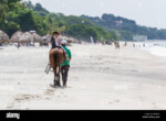 santa-clara-panama-june-12-young-boy-on-a-horse-riding-along-the-beach-H54RFK